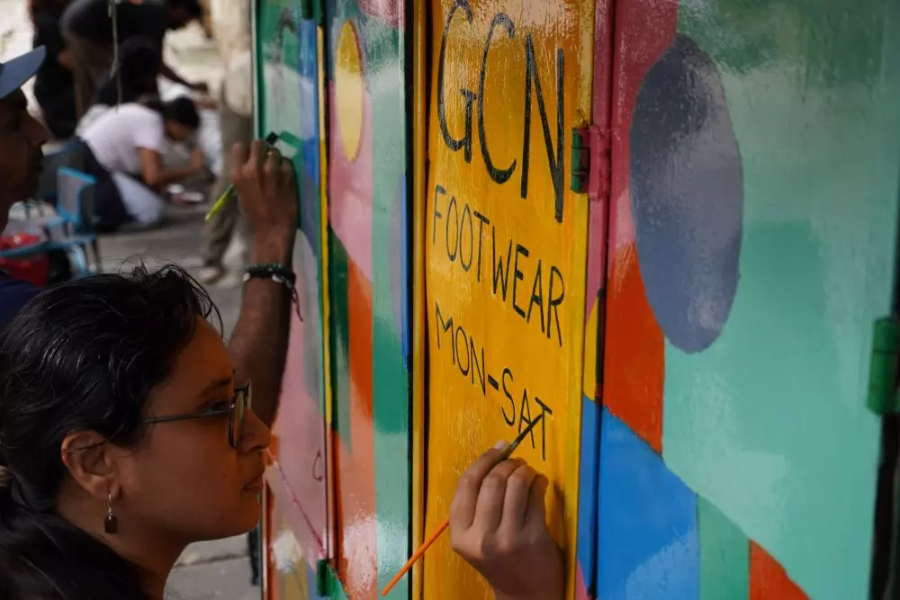 Participants in the Cooke Town, Bengaluru, project paint a cobblers shop in the neighbourhood as part of the initiative. Photo: By special arrangement