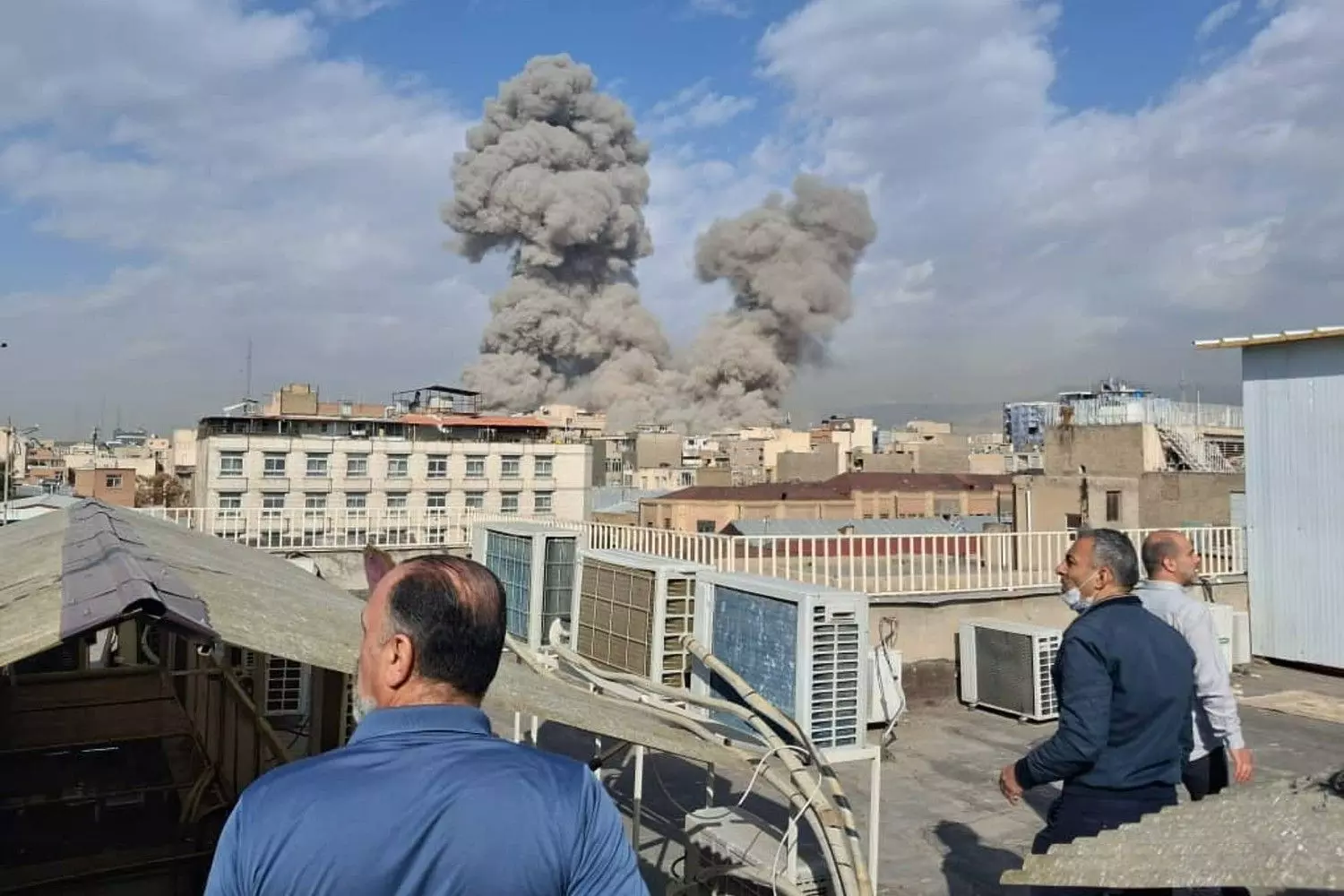 People watch as smoke rises on the skyline after an explosion in Tehran, Iran, Saturday, February 28. AP/PTI People watch as smoke rises on the skyline after an explosion in Tehran, Iran, Saturday, February 28. AP/PTI
