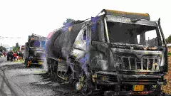 Charred remains of fuel tankers lie on a road after they were set ablaze by people