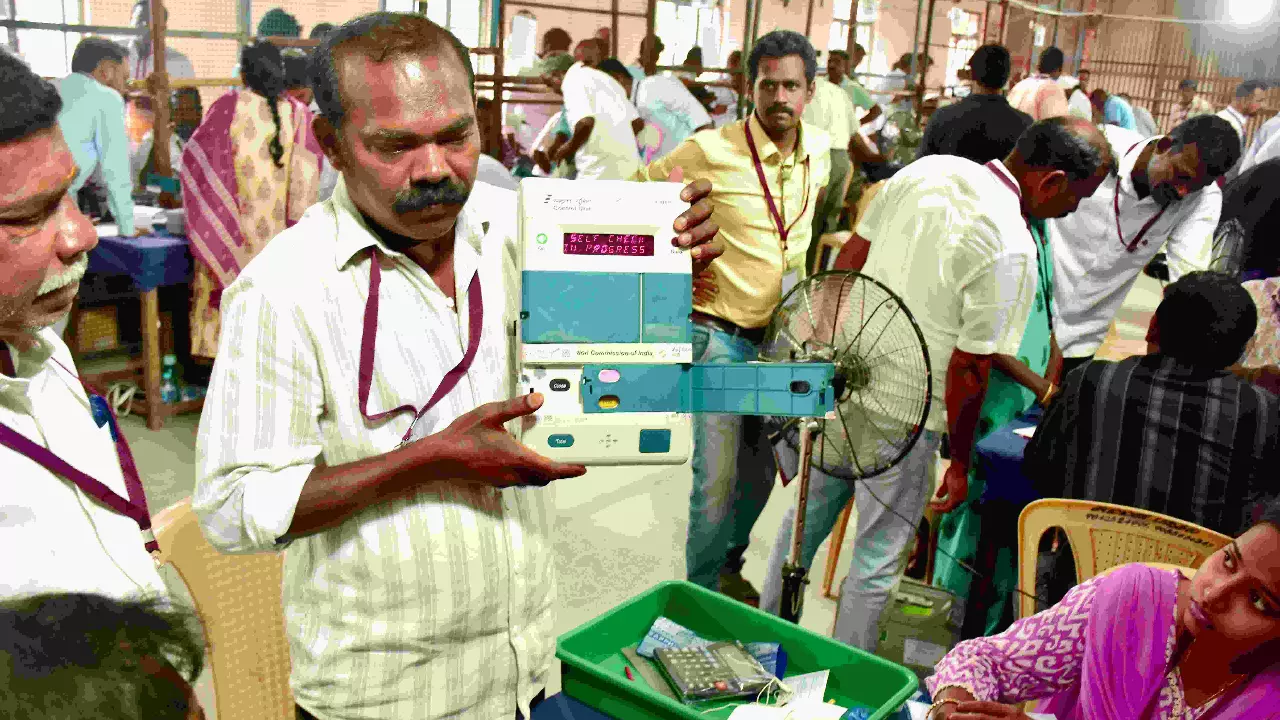 An election official demonstrates an electronic voting machine (EVM) during vote counting at a counting centre, in Madurai