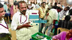 An election official demonstrates an electronic voting machine (EVM) during vote counting at a counting centre, in Madurai