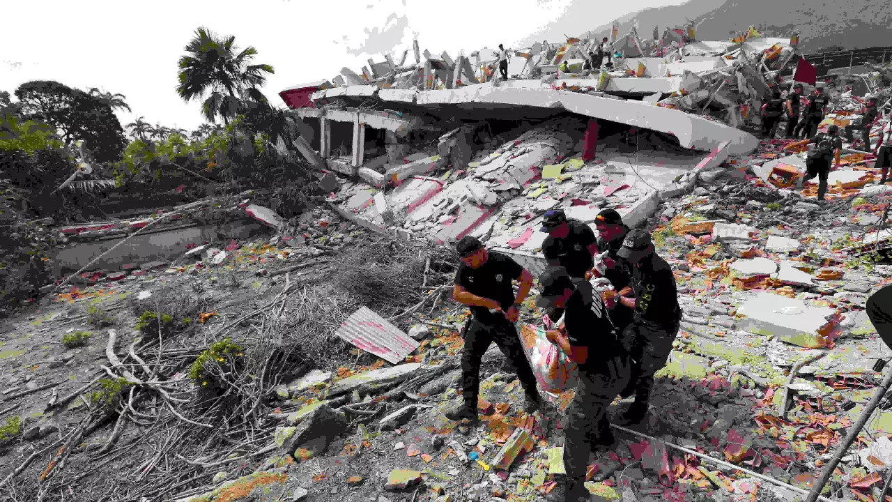 A man walks among the rubble of a building that collapsed in earthquakes the previous day in La Guaira, Venezuela