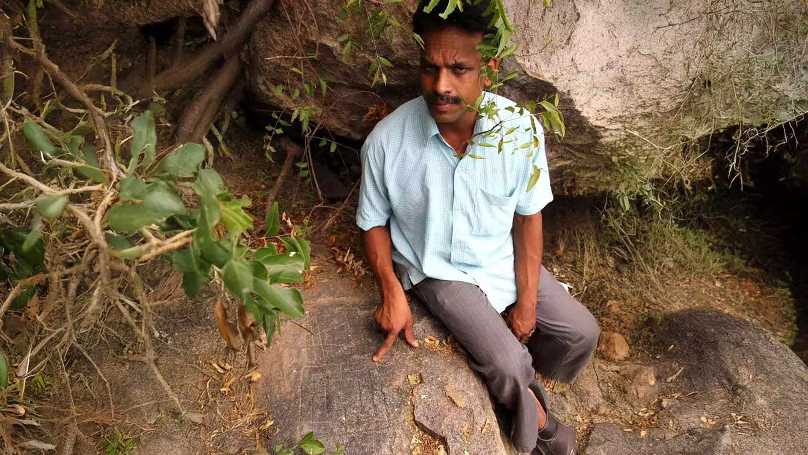 Jeevakumar points at Jain symbols cut on a rock. Photo: MT Saju
