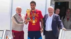 Spains Rodrigo Hernandez (Centre) holds the World Cup trophy after arriving in Madrid