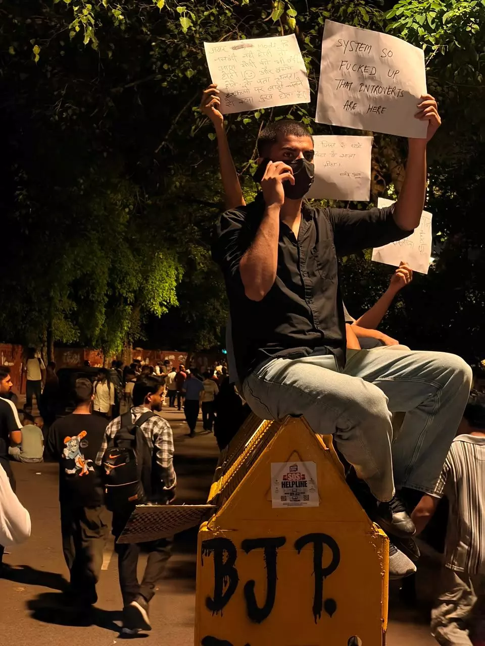 Show of resilience: A protestor sits atop a barricade, meant to contain the agitation, holding placards. Photo: Eshan Sharma Show of resilience: A protestor sits atop a barricade, meant to contain the agitation, holding placards. Photo: Eshan Sharma