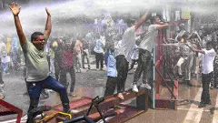 Police personnel use water cannons to disperse students protesting against alleged irregularities in recruitment examinations