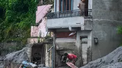 People amid damage in the aftermath of flash floods in Devighat in the Nuwakot district in Nepal