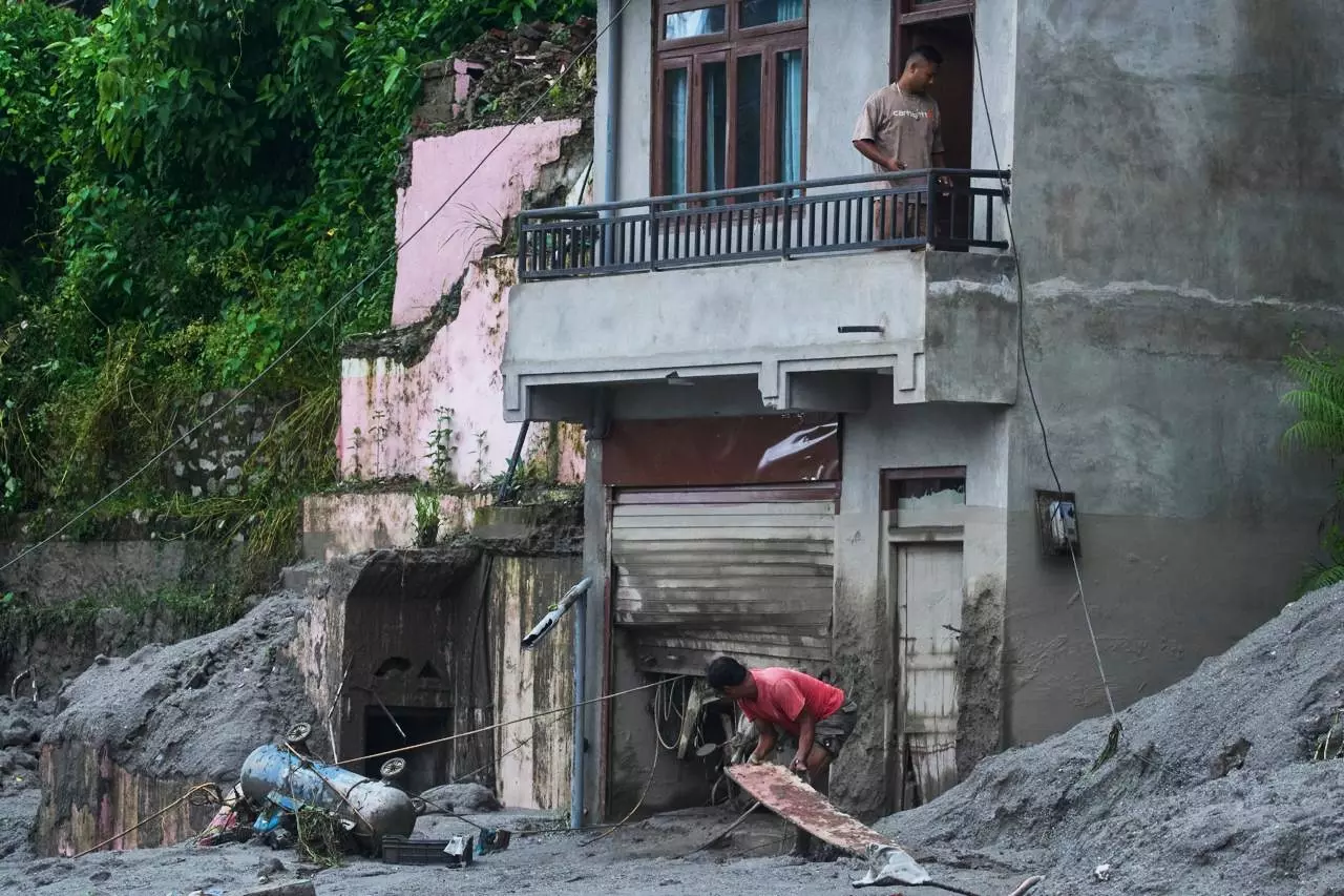 People amid damage in the aftermath of flash floods in Devighat in the Nuwakot district in Nepal People amid damage in the aftermath of flash floods in Devighat in the Nuwakot district in Nepal