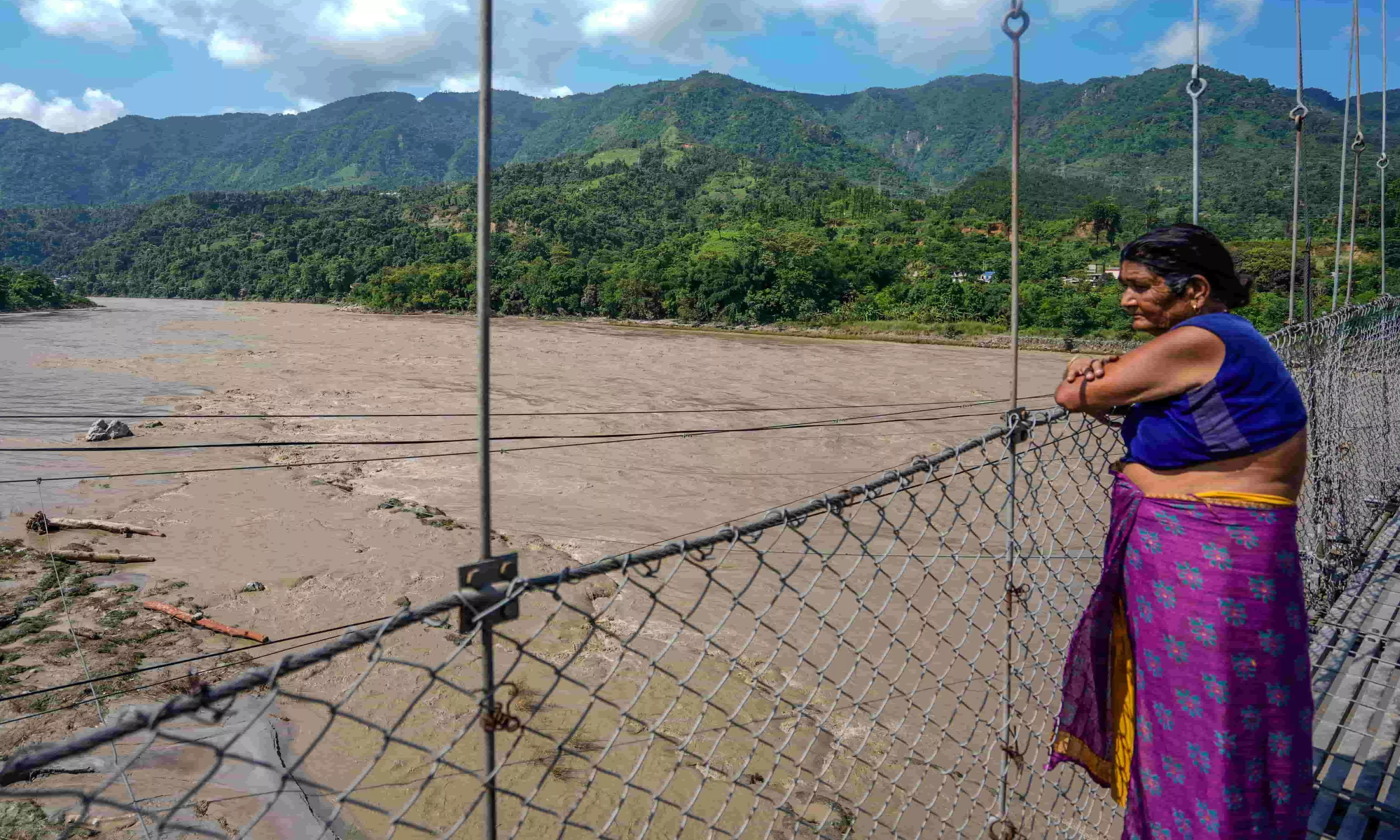A woman looks at the indundated area after flash floods, in the Devghat area, Nepal, Thursday, Aug. 27, 2026 A woman looks at the indundated area after flash floods, in the Devghat area, Nepal, Thursday, Aug. 27, 2026