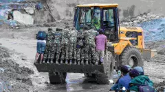 Security personnel stand on an excavator at a muddy area in the aftermath of flash floods, at Trishuli market, in Nuwakot district in Nepal Security personnel stand on an excavator at a muddy area in the aftermath of flash floods, at Trishuli market, in Nuwakot district in Nepal
