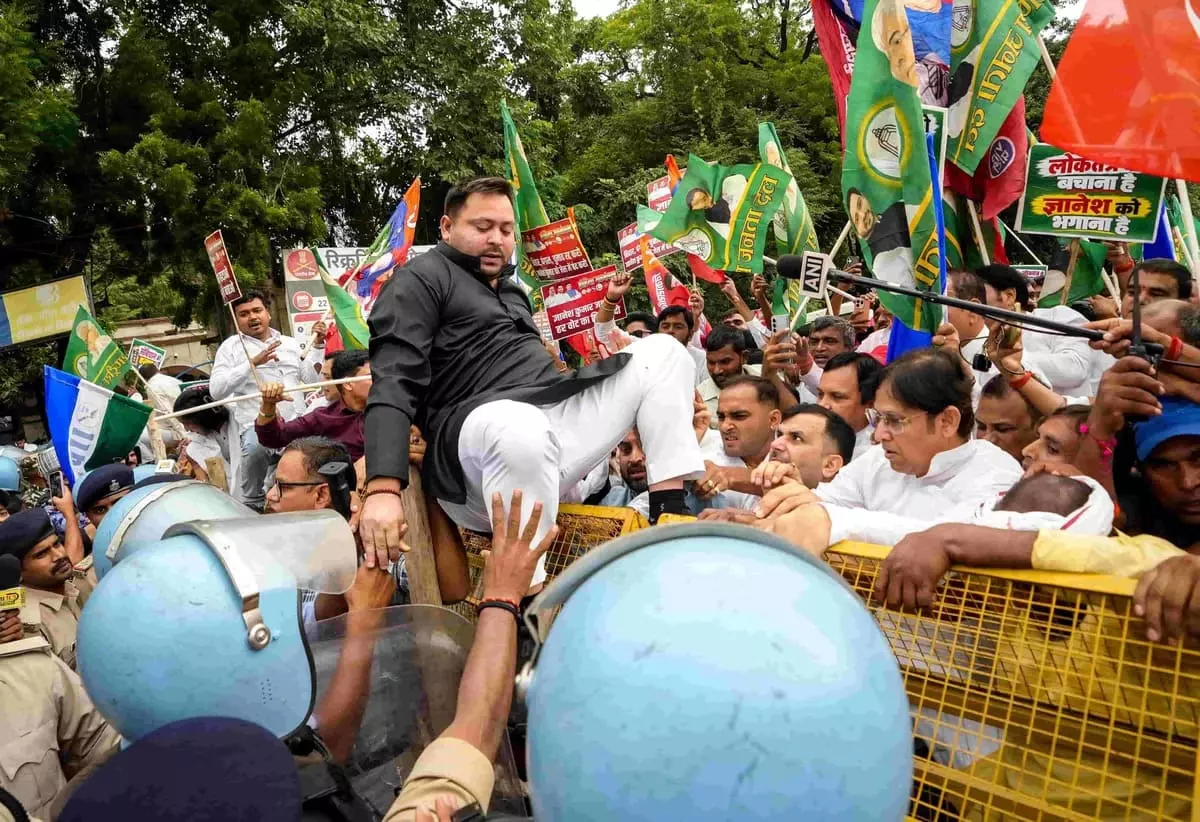 Bihar Leader of Opposition and RJD leader Tejashwi Yadav climbs over police barricades Bihar Leader of Opposition and RJD leader Tejashwi Yadav climbs over police barricades