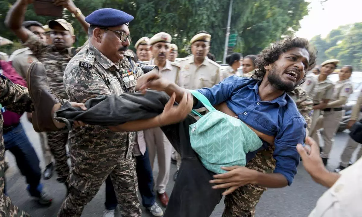 Security personnel detain an activist during a protest demanding the resignation of Chief Election Commissioner Gyanesh Kumar over SIR Security personnel detain an activist during a protest demanding the resignation of Chief Election Commissioner Gyanesh Kumar over SIR