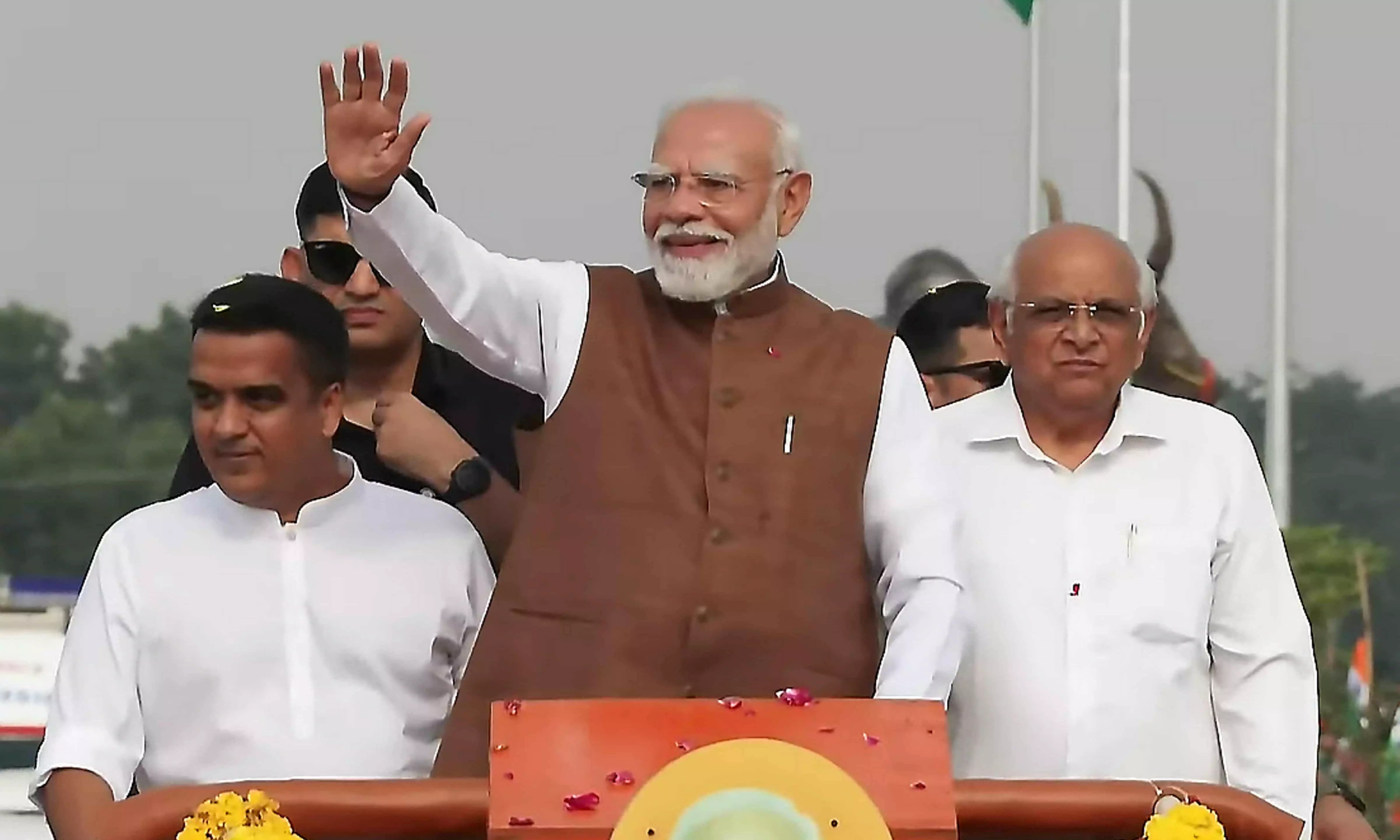 Prime Minister Narendra Modi greets people during a roadshow upon his arrival, in Banaskantha district Prime Minister Narendra Modi greets people during a roadshow upon his arrival, in Banaskantha district